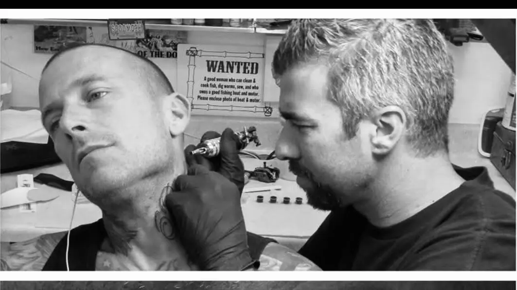 3445840207464968149 A man getting his face tattooed by another man.