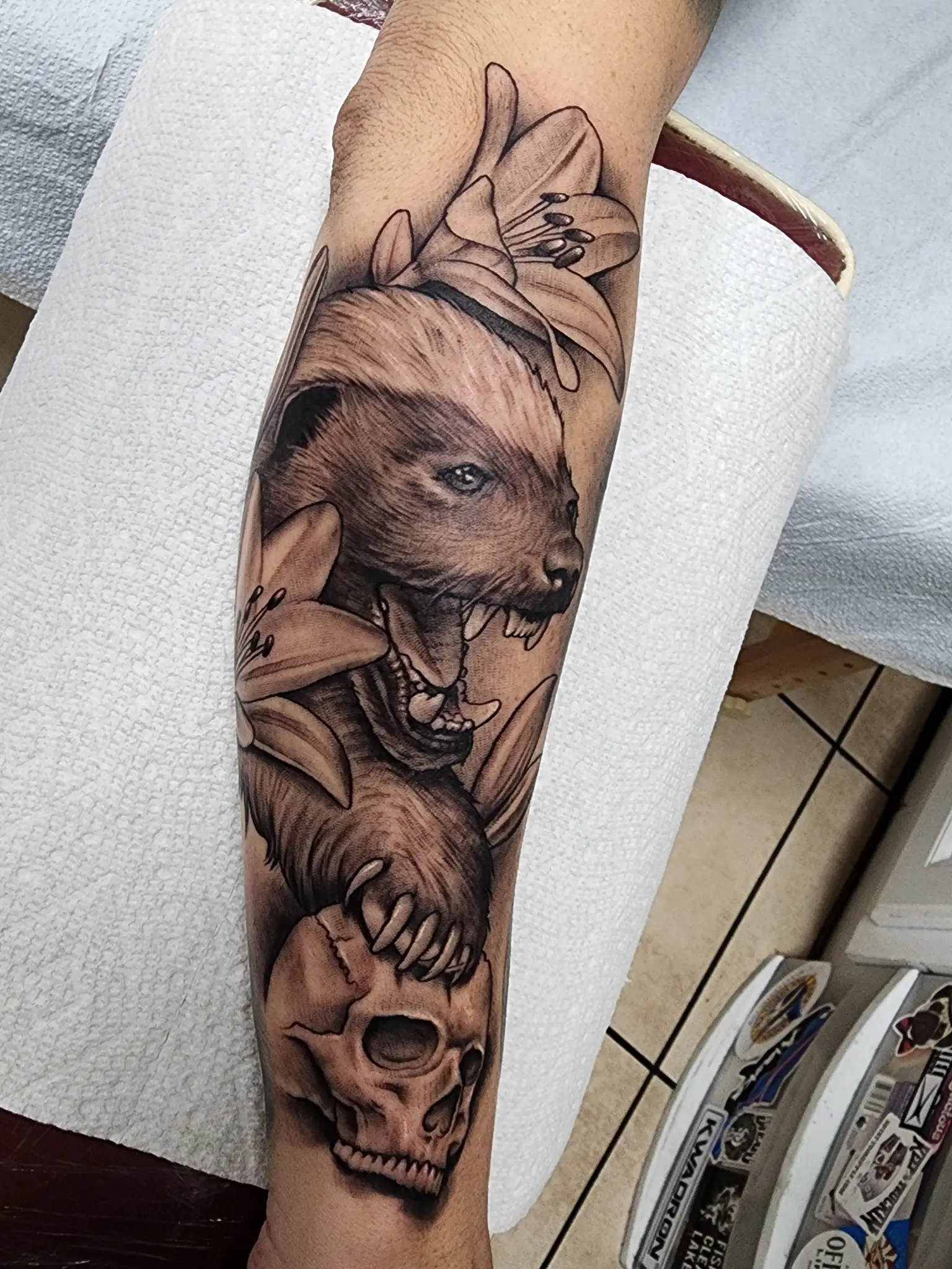 A tattoo of a bear and skulls on the arm.