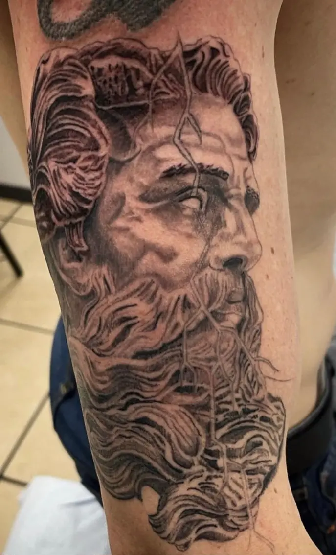 A man with long hair and beard on his arm