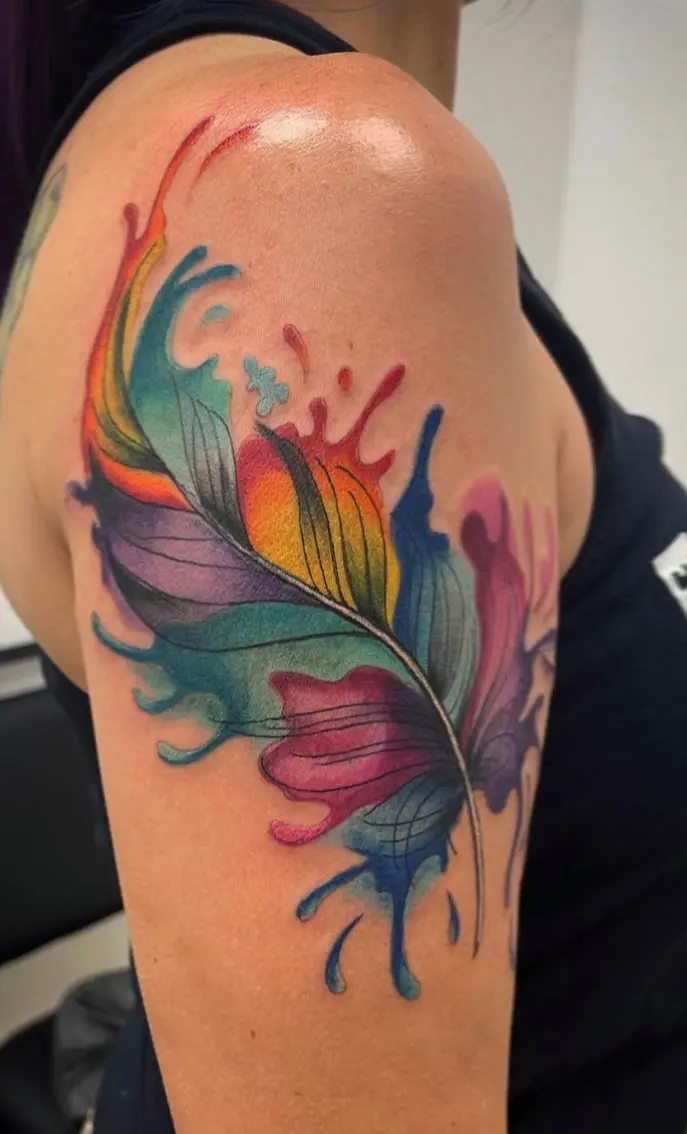 A colorful feather tattoo on the arm of a woman.
