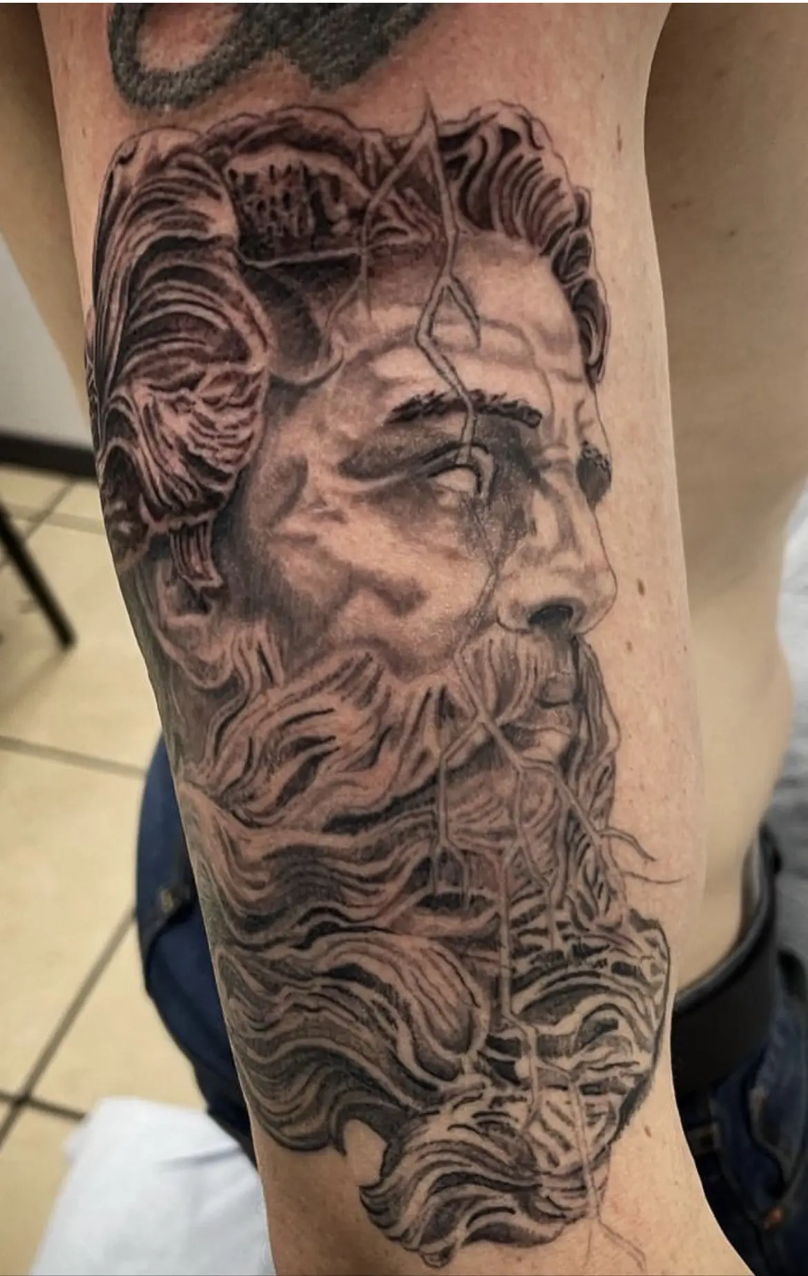 A man with long hair and beard on his arm