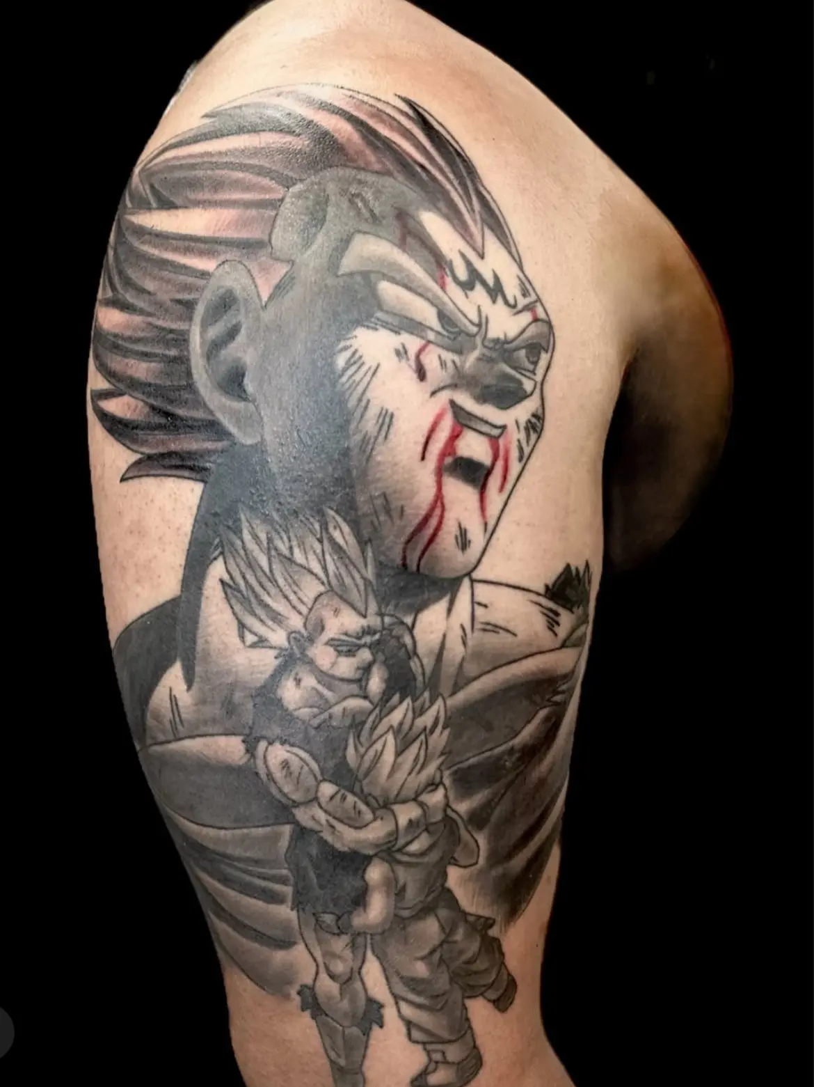 A man with tattoos on his arm and shoulder.