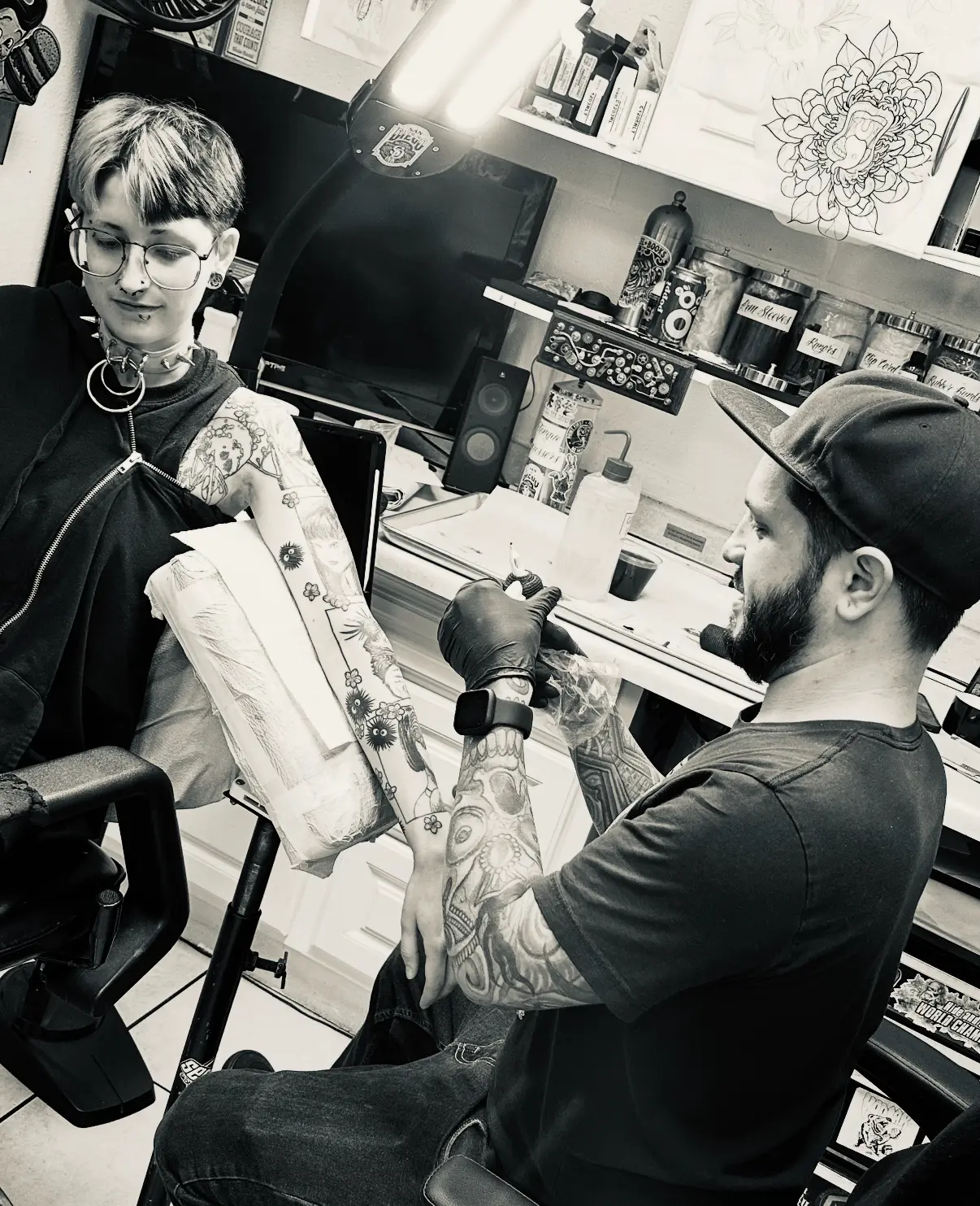 A man and woman in a tattoo shop.