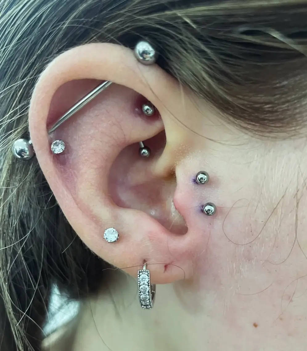A woman with multiple piercings on her ear.