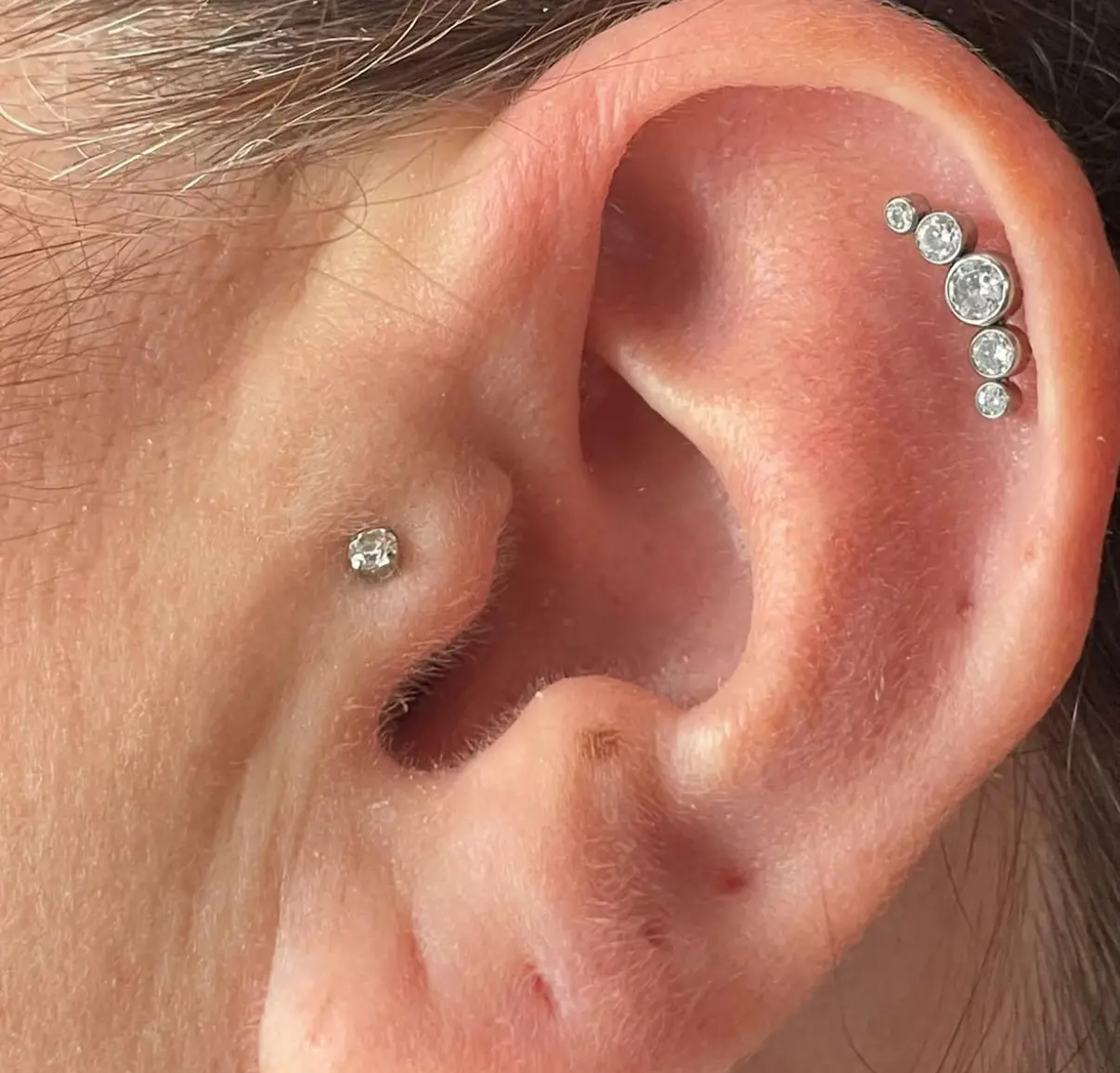 A woman with multiple piercings on her ear.