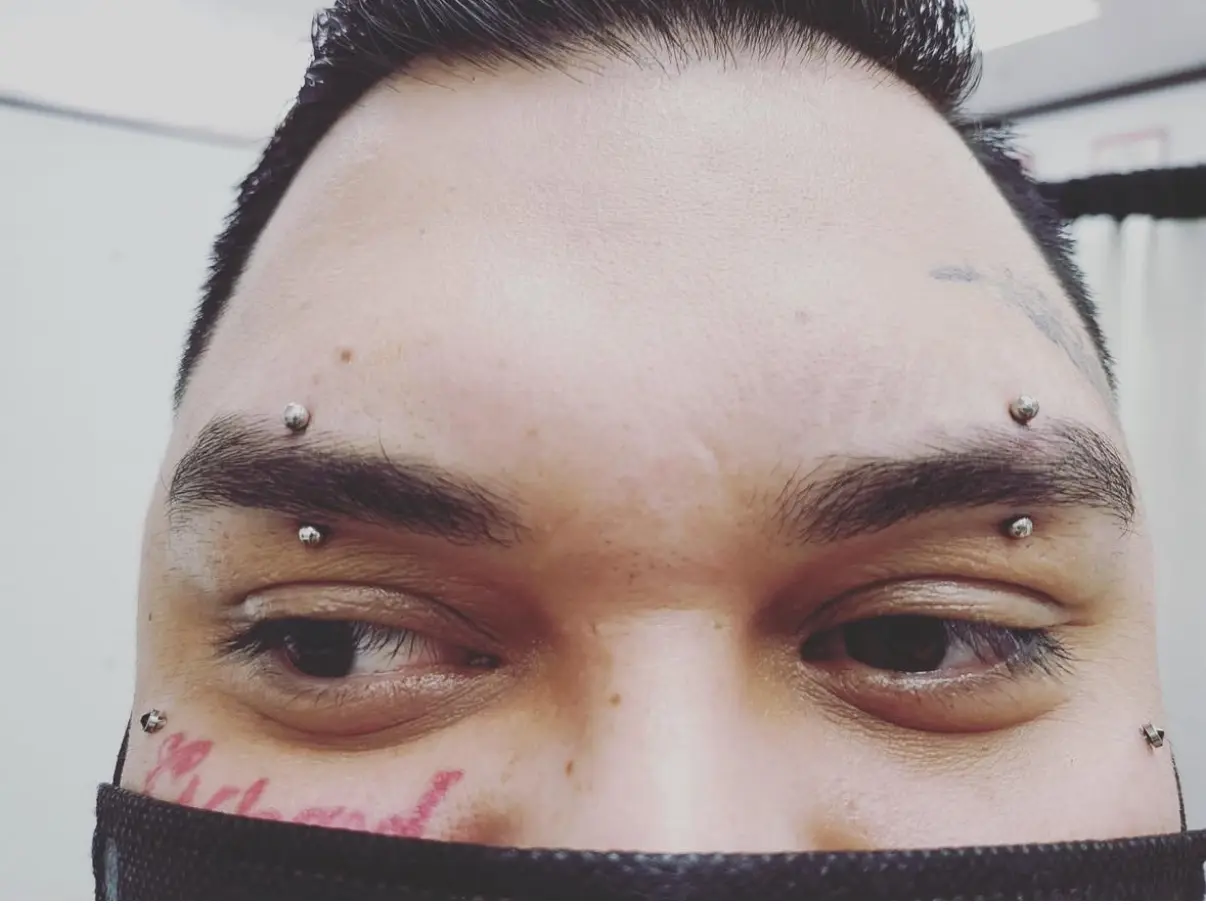 A man with tattoos on his face and eyebrows.