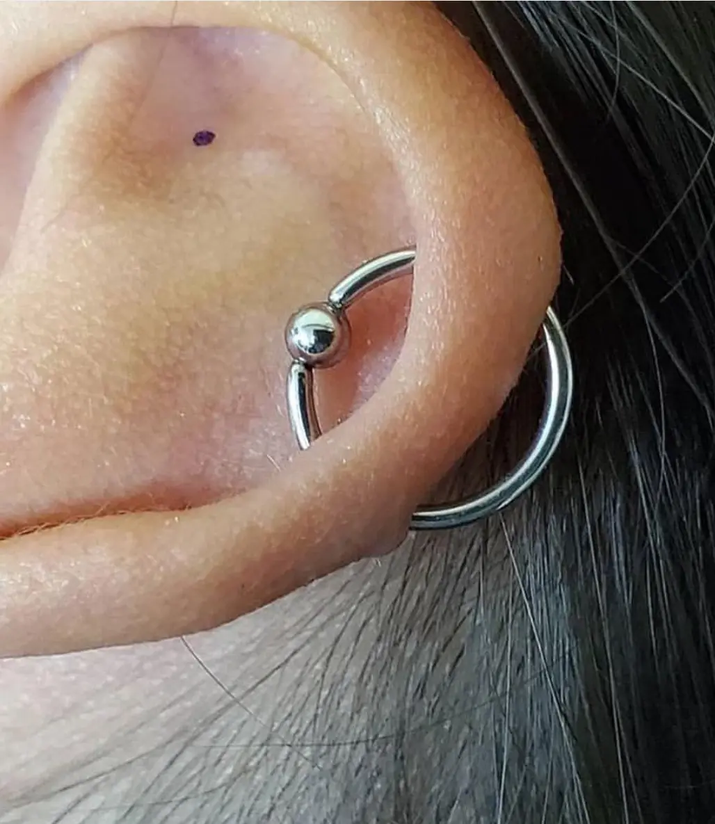 A close up of a person wearing an ear piercing